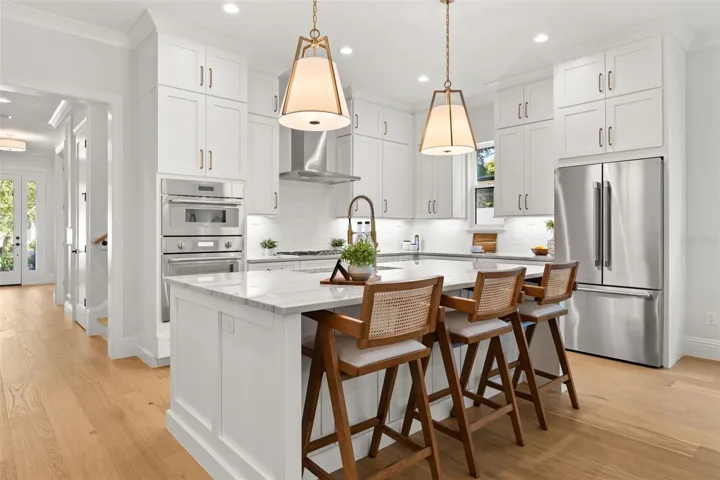 The Kitchen hosts Thermador appliances, to include the refrigerator, a built-in microwave/oven combo, a natural gas cooktop and dishwasher.  The stainless steel hood is vented outside.  The custom designed kitchen has cabinets that extend to the 10’ ceilings, along with additional storage on the back side of the island, as well as a walk-in pantry closet.