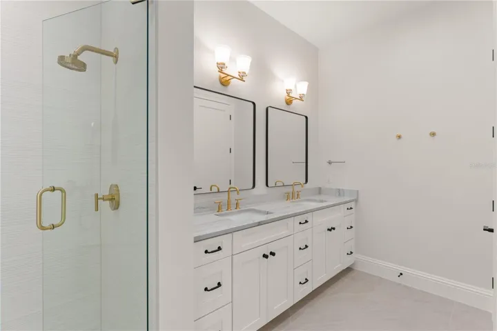 The walk-in shower has a frameless enclosure, double shower heads, one with a slide bar that adjust to varying heights, a shower seat
