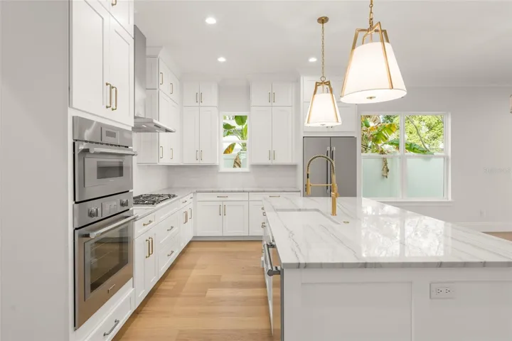 The Kitchen hosts Thermador appliances, to include the refrigerator, a built-in microwave/oven combo, a natural gas cooktop and dishwasher.  The stainless steel hood is vented outside.  The custom designed kitchen has cabinets that extend to the 10’ ceilings, along with additional storage on the back side of the island, as well as a walk-in pantry closet.