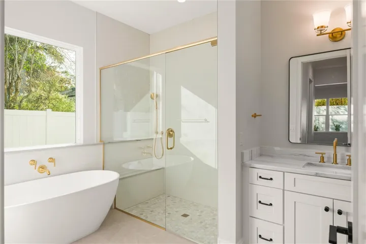 The primary bathroom has a large walk-in shower with double shower heads, one stationary and the second is a hand held on a slide bar.  There is a large soaker tub, a private water closet, a double sink vanity and a linen closet.