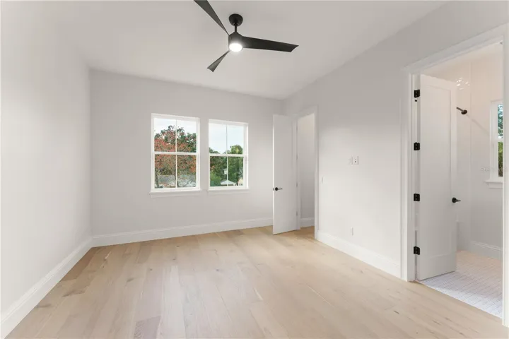 Bedroom 2 has engineered wood flooring, ceiling fan with remote control, ensuite bathroom, and a walk-in closet with built-in custom closet shelving.