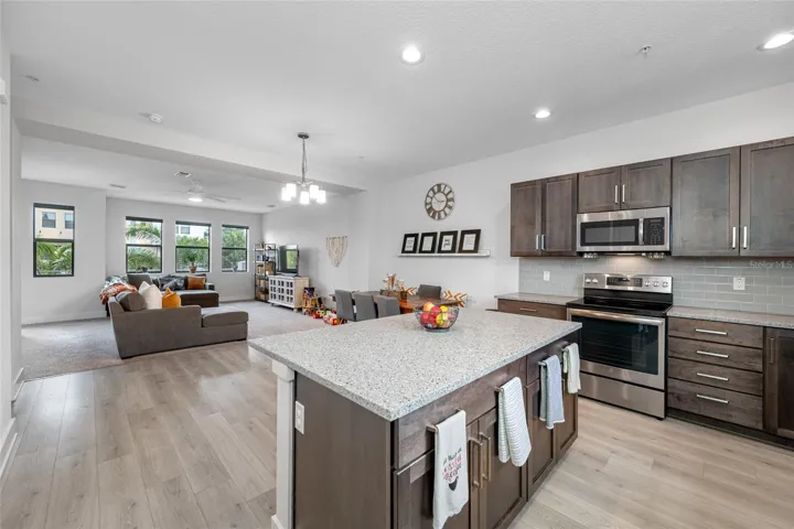 Gourmet kitchen with quartz countertops, Open to the dinning and living room. 10 ft ceilings and oversized windows let in lots of natural light. Second Floor