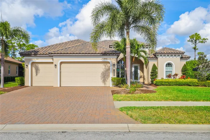Front view.  Brick paver driveway and lush Florida landscape