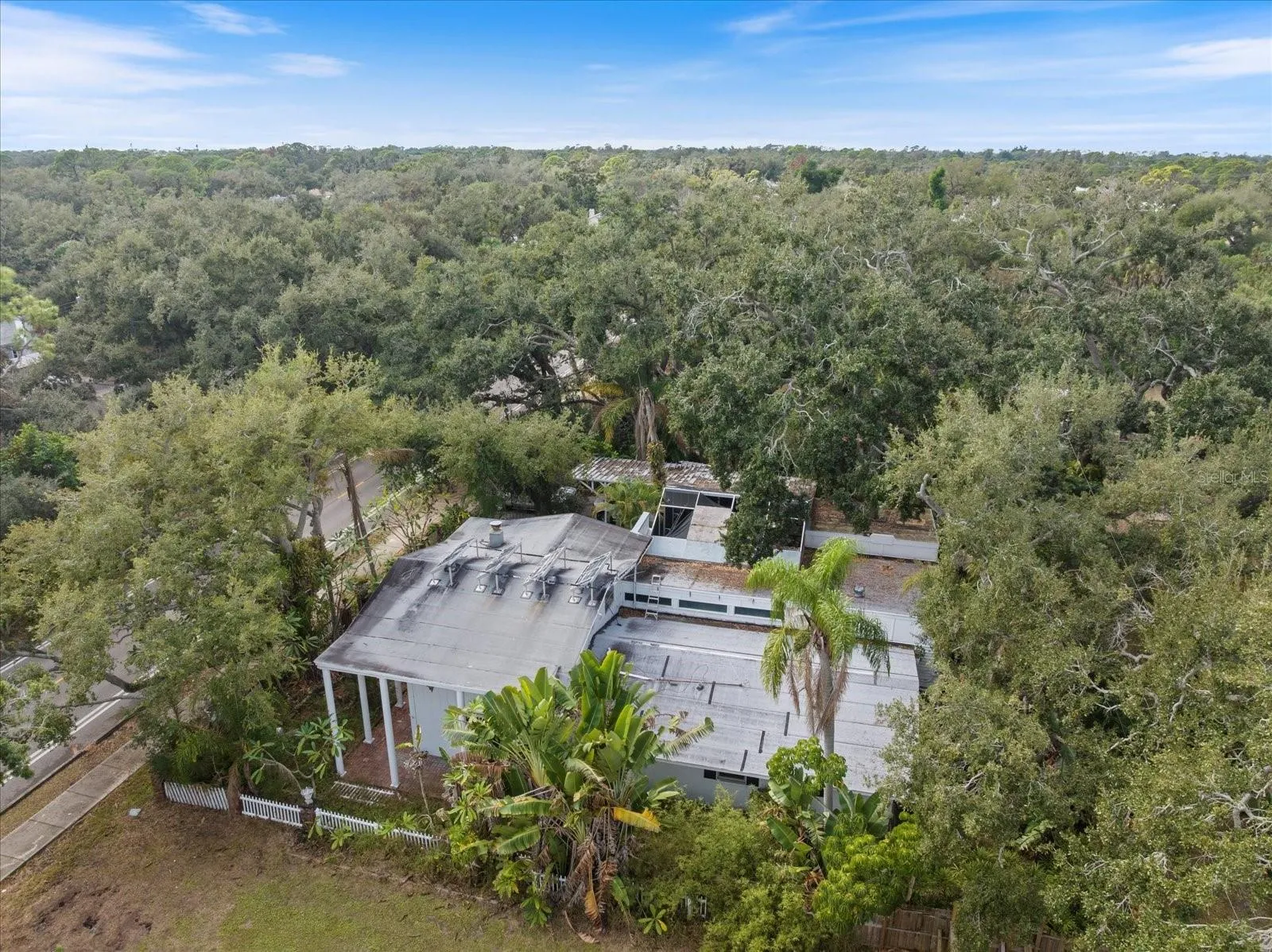 aerial of home. Main home is at far right of .46 acre lot. There is a lot with a guest house that can be included for right price to make a total of .73 acres. This home is perfect for an arborist or builder.
