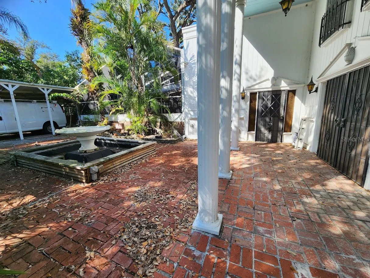 fountain and left side of house by carport and pool cage