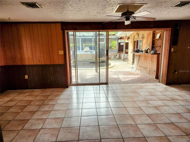 family room with triple sliders to pool area and bar