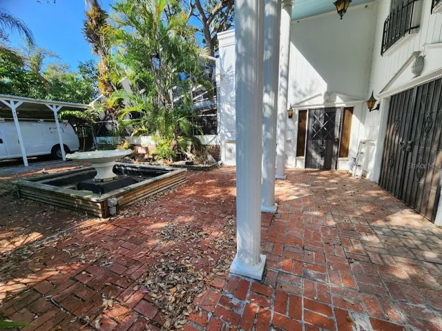 fountain and left side of house by carport and pool cage