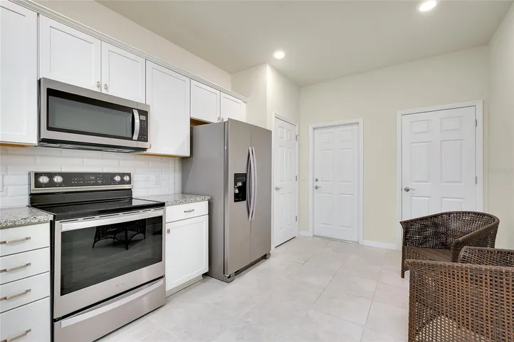 Owners upgraded the kitchen with the white subway tile backsplash. Pantry door is to the left, Garage door straight back and the air handle is behind the door on the right.