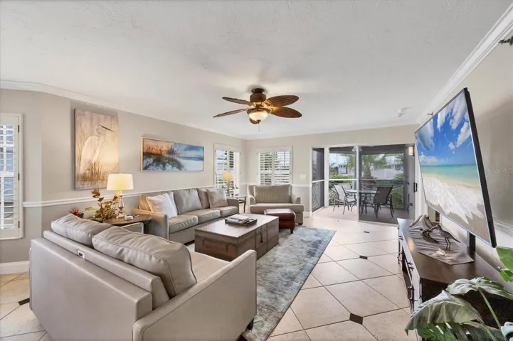 Living Room extends out to the lanai and offers views overlooking a lake, pool and marina