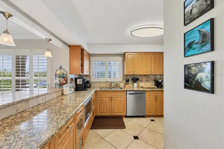 Kitchen has stainless appliances and granite counters with a tiled backsplash