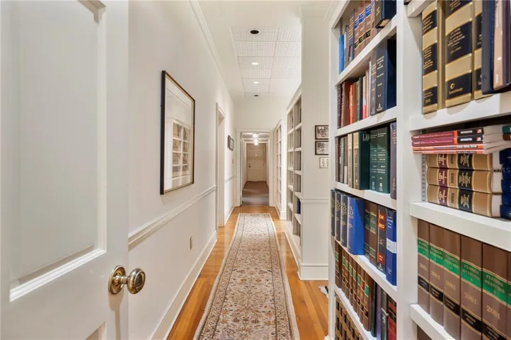 The hall to the remaining offices is adorned with wonderful built-in bookcases, the entrance to the Mens & Ladies bathrooms , copy room and a terrific kitchen. In the rear of the photo is the exit to the parking lot.