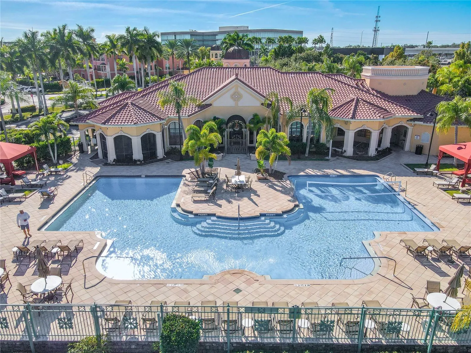This aerial view further shows the resort-style heated clubhouse pool and spa with a spacious sundeck, lounge seating, and private rentable cabanas—perfect for relaxing, entertaining, and soaking up the Florida sunshine.