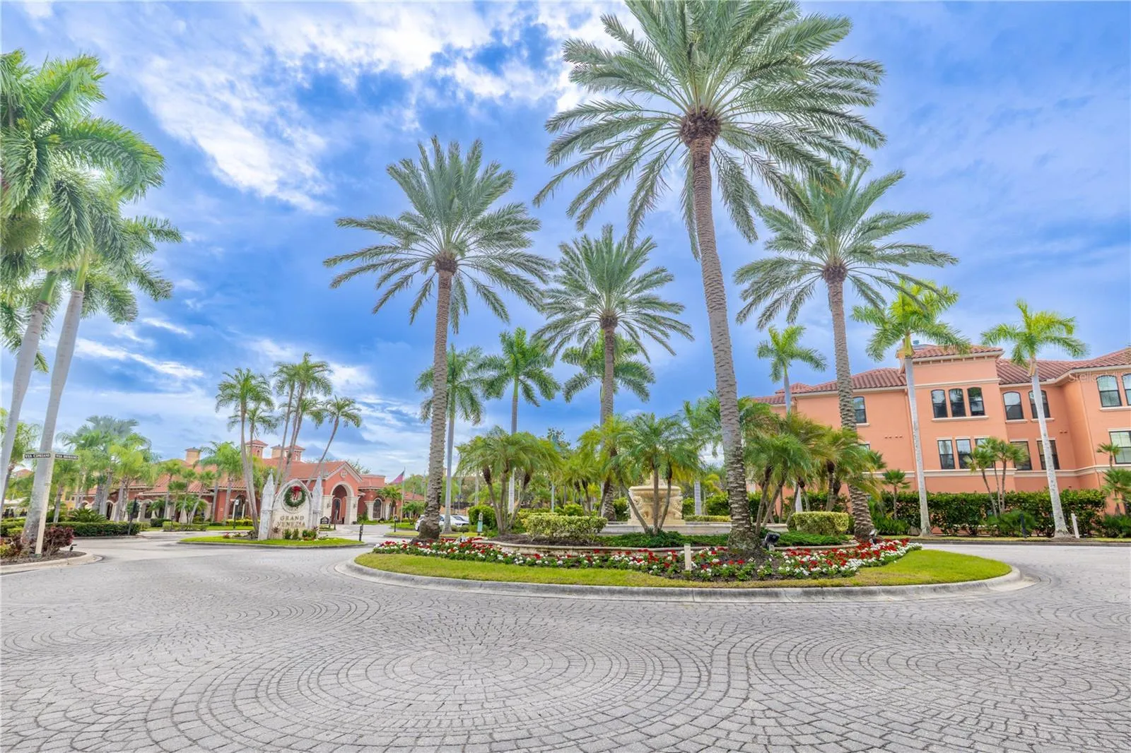 A coveted second-floor corner residence, bathed in natural light, sits gracefully within this palm-lined Mediterranean-style community.