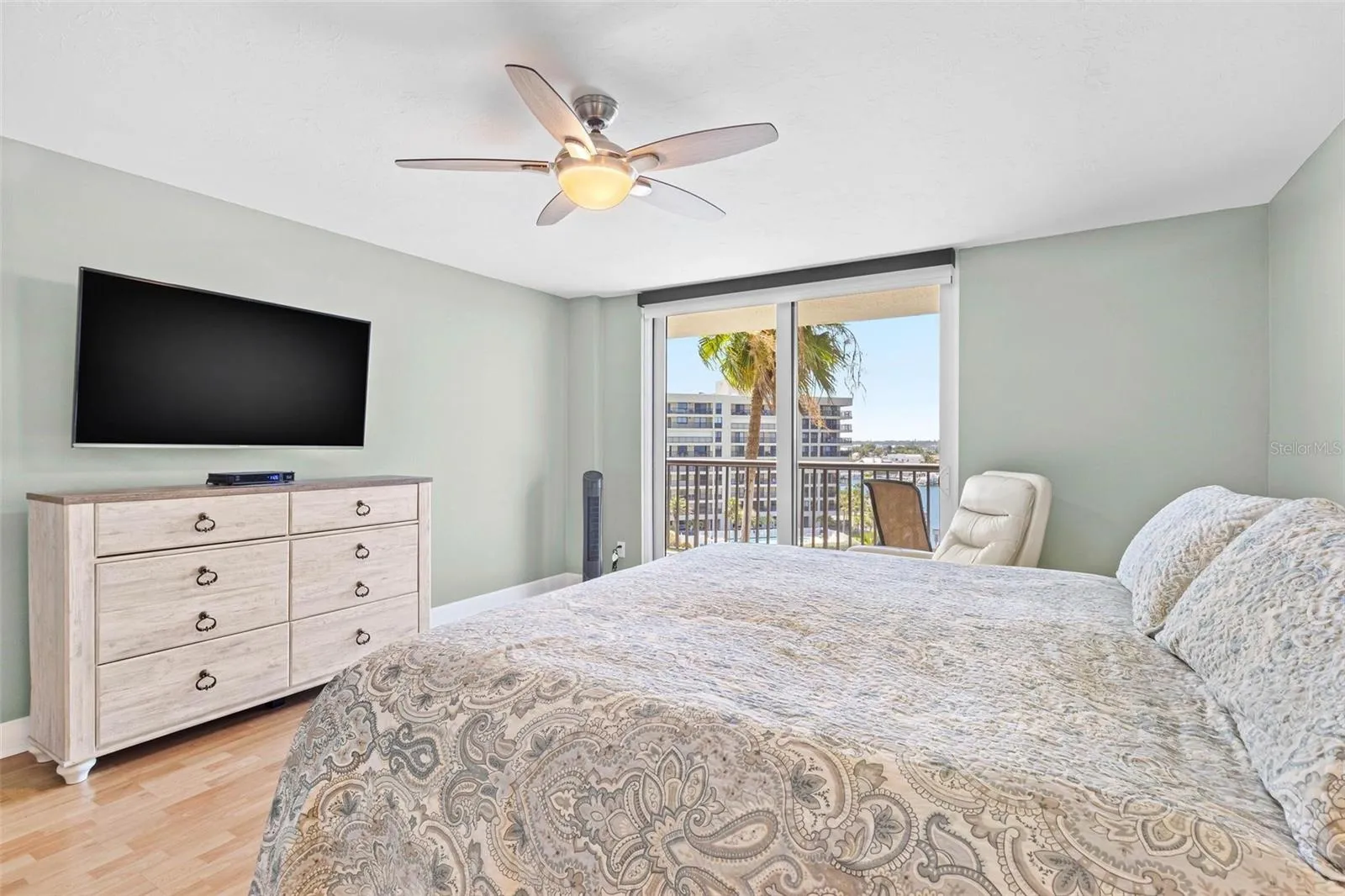 primary bedroom with bathroom en suite, water view and balcony