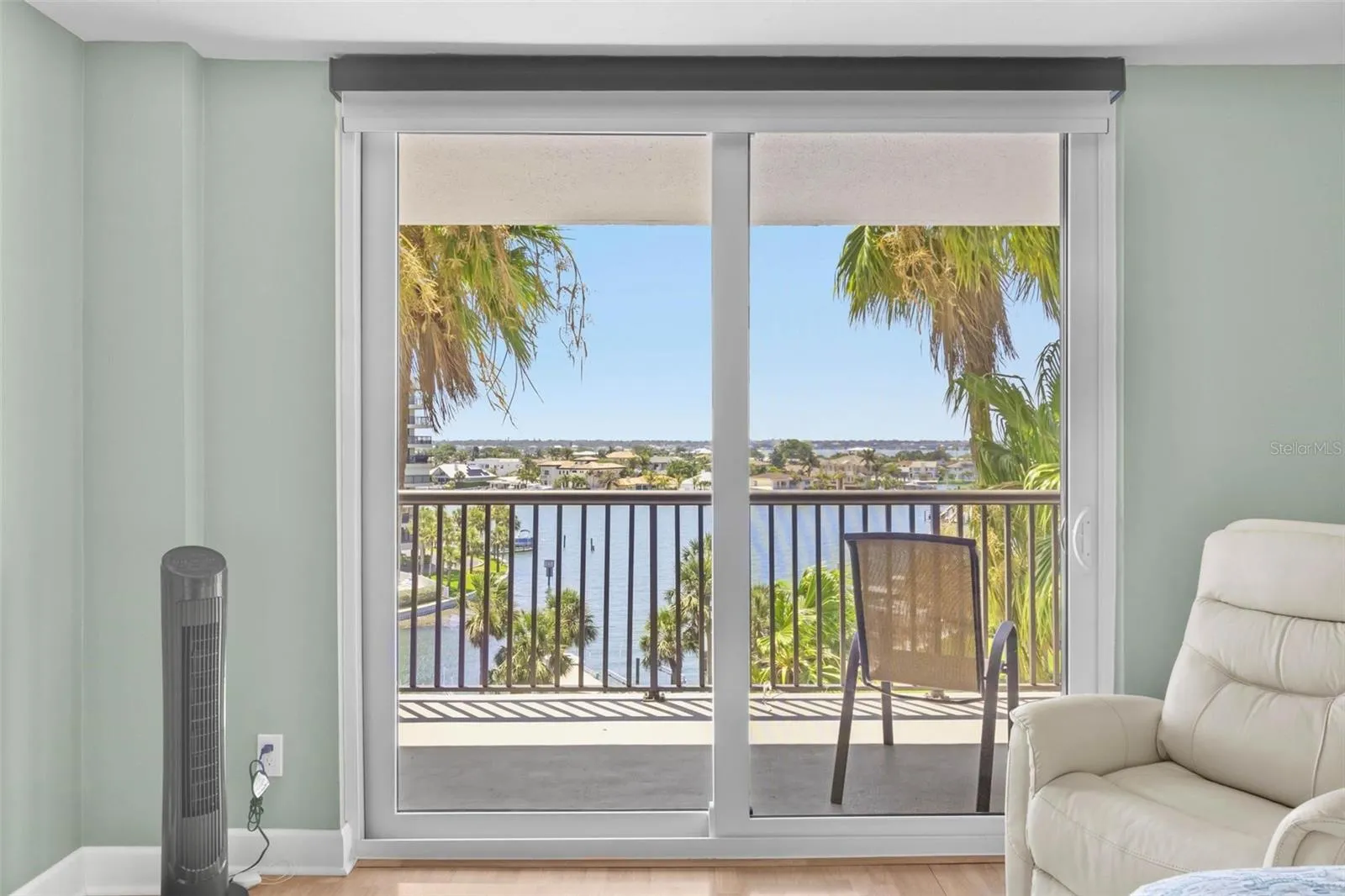 primary bedroom with bathroom en suite, water view and balcony access