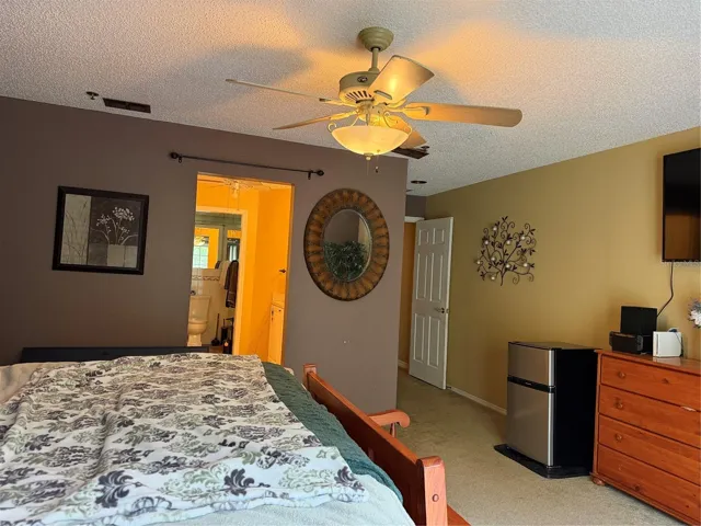 Primary bedroom has a ceiling fan with light kit.
