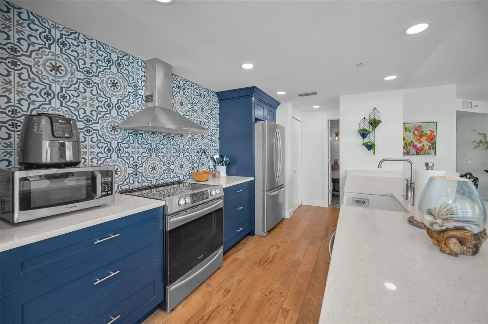 Cucina Features Versay Grand Blue Encaustic Style Porcelain Tile Backsplash, Stainless appliances, Quartz Counter Surfaces, Custom Shaker Style Cabinetry, Farmhouse Apron Front Sink &amp; more.