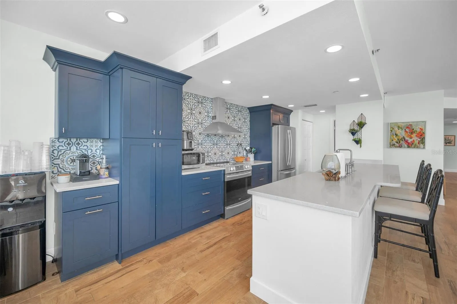 Cucina Features Versay Grand Blue Encaustic Style Porcelain Tile Backsplash, Stainless appliances, Quartz Counter Surfaces, Custom Shaker Style Cabinetry, Farmhouse Apron Front Sink &amp; more.