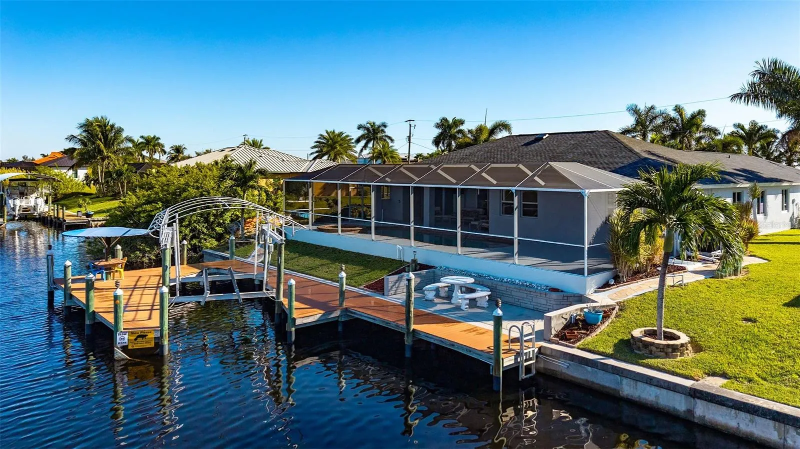 Canal view of deck, boat life, tiki hut, full lanai