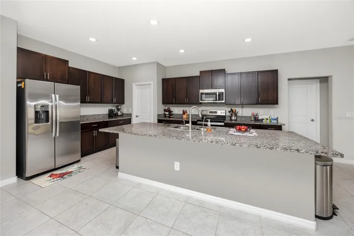 Large kitchen with expansive island, granite counters, and easy-care tile make the heart of this home!
