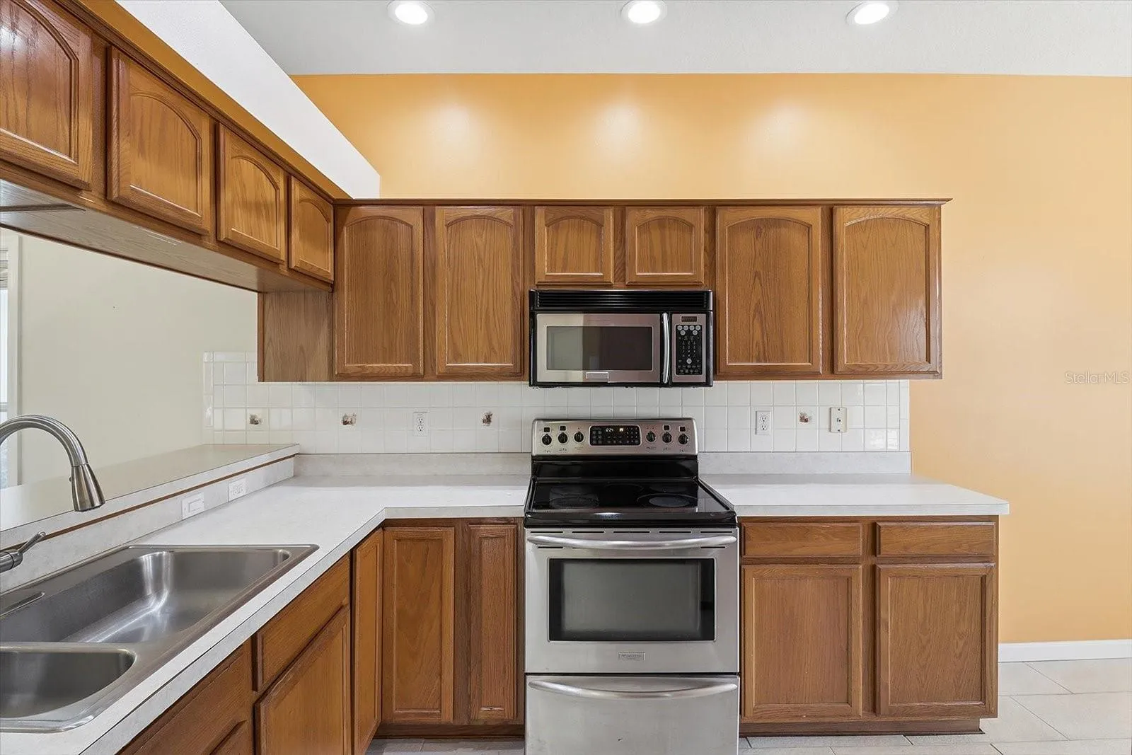 Kitchen w/ Stainless Steel Appliances, NEW Dishwasher, Tiled Backsplash, Breakfast Bar & Plenty of Cabinets & Countertops