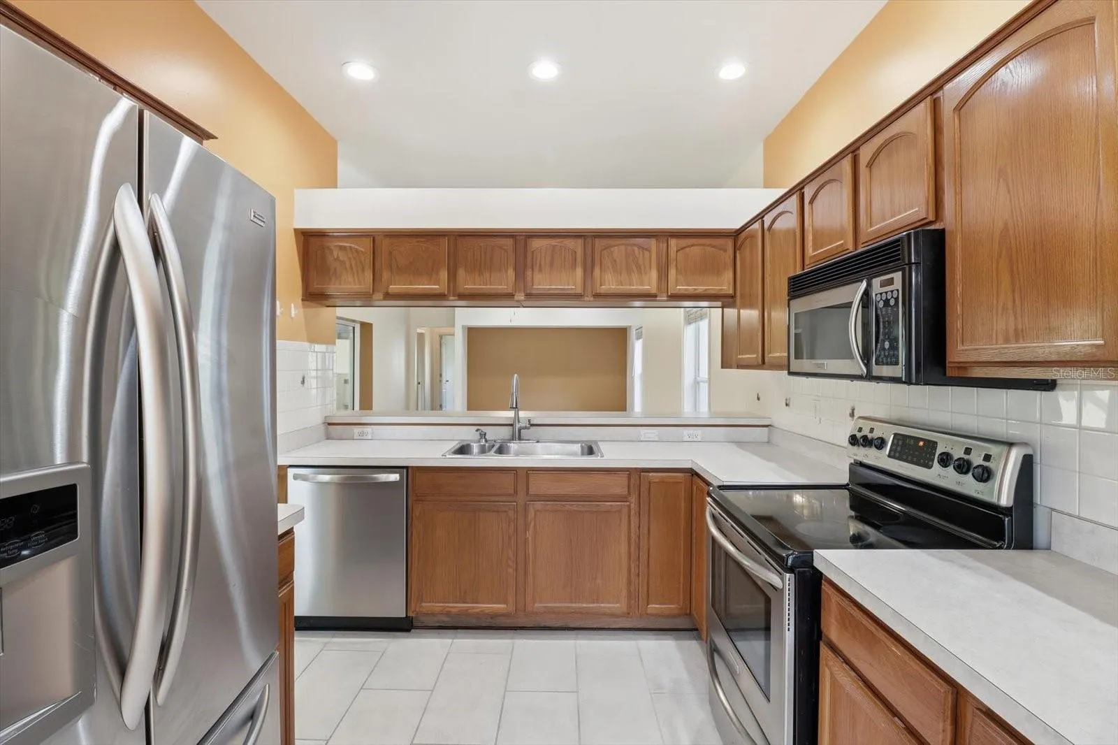 Kitchen w/ Stainless Steel Appliances, NEW Dishwasher, Tiled Backsplash, Breakfast Bar & Plenty of Cabinets & Countertops