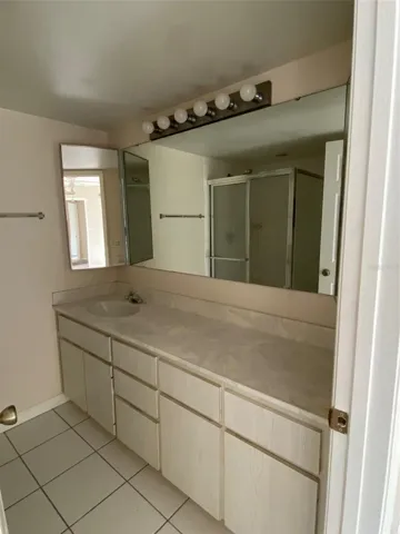 Ceramic tile flooring, Hollywood lighting, 2 medicine cabinets - one on either side of vanity and lots of drawers and covered shelves for toiletries and personal items