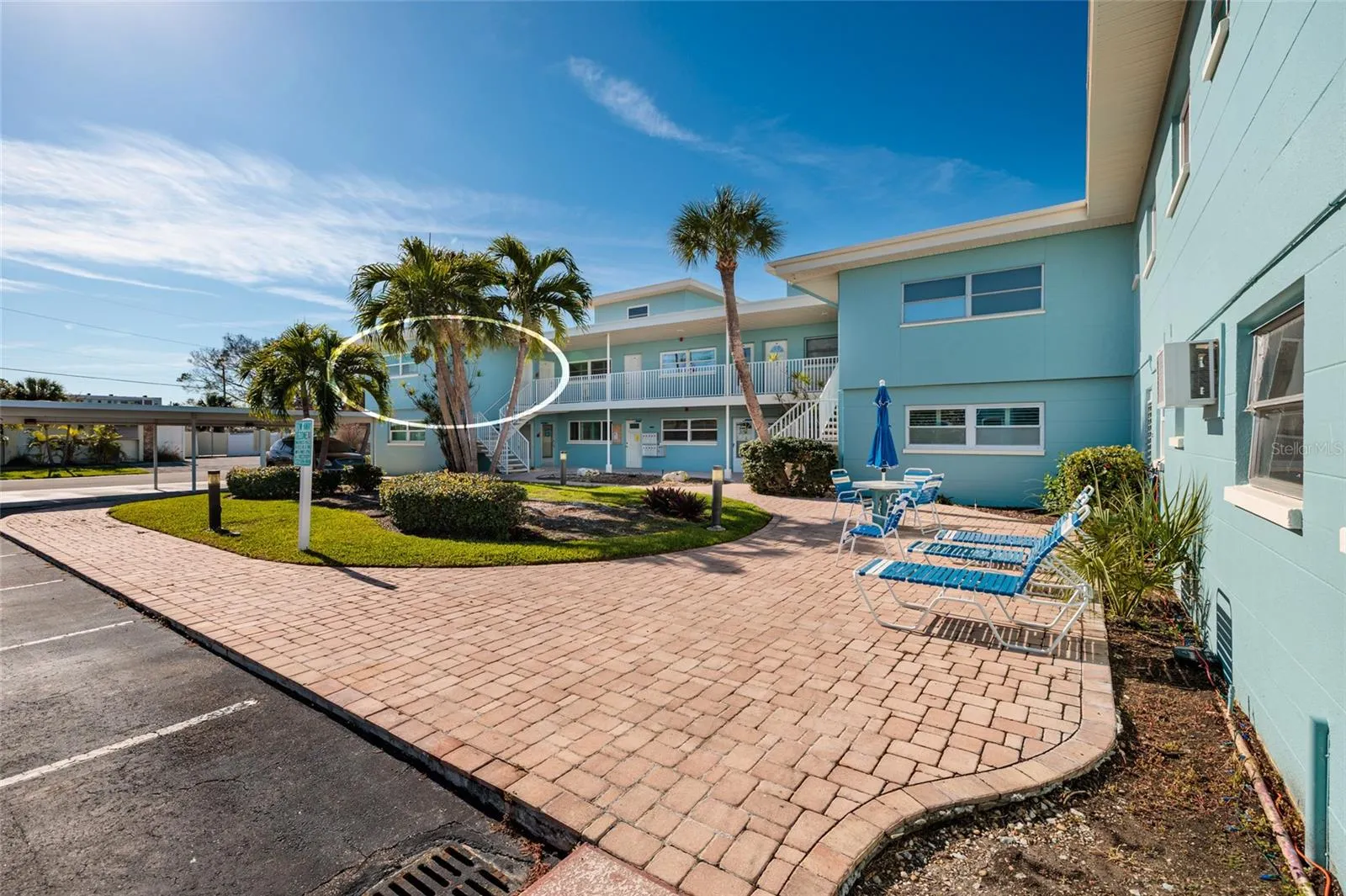 Unit 6 &amp; courtyard. Laundry/storage room is to the right of the table w/umbrella.