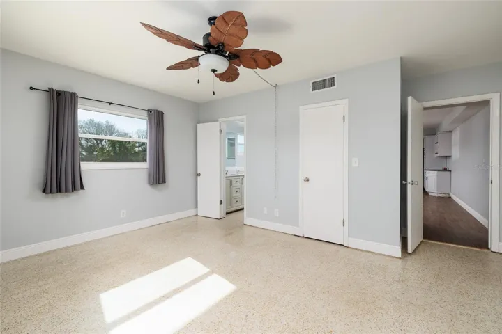 Primary bedroom. En-suite bath & closed door is walk-in closet. Doorway to living room. Private bedroom door to outside walkway/porch is out of pic on right.