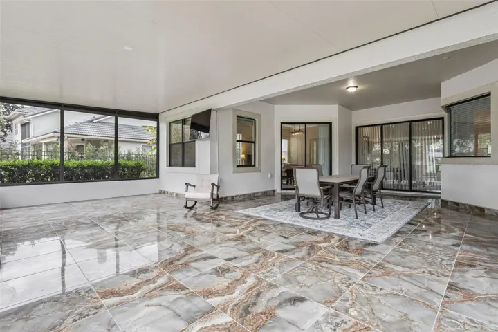 An entertainer’s dream lanai—massive covered and screened space with gorgeous tile flooring, plenty of room for dining and lounging, and effortless flow back into the home.