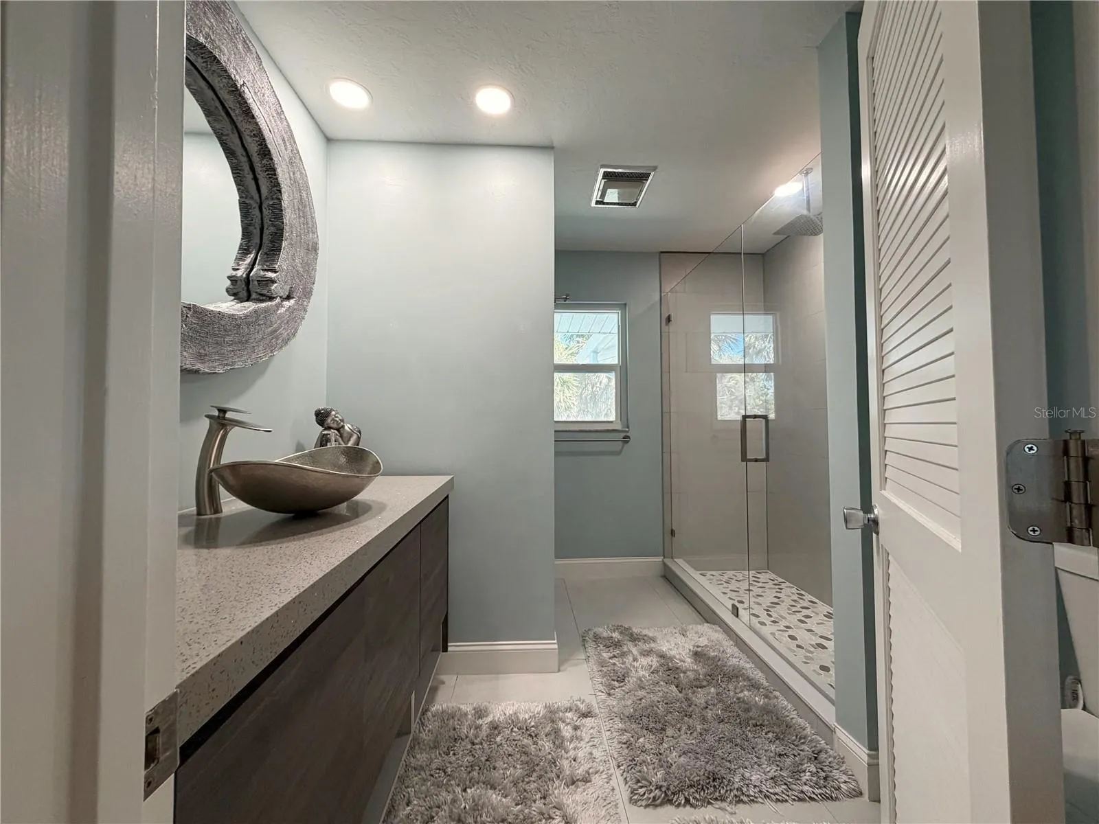 Guest bathroom featuring a walk-in shower and updated finishes.