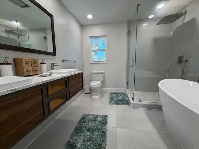Primary bath with dual vanity, walk-in shower, and soaking tub.