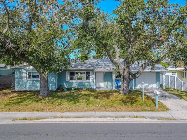 Charming single-story ideally located, Seminole home showcases a welcoming curb appeal with mature shade trees, a spacious driveway, and an attached garage.