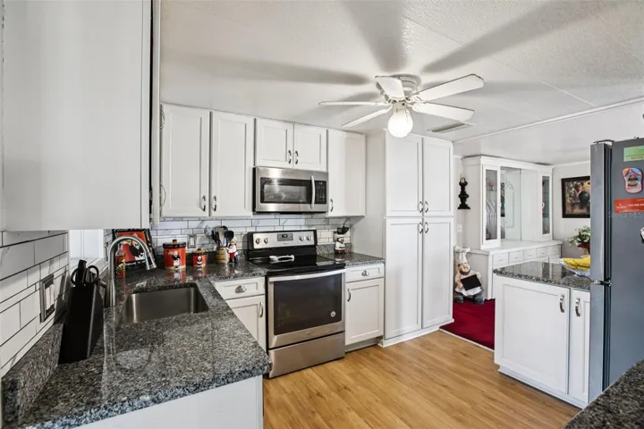 Kitchen facing dining room, showing updated cabinets and backsplash.