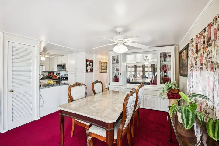 Dining room facing kitchen, showing ceiling fan.