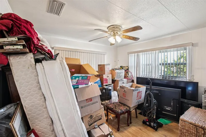 Secondary bedroom showing windows and ceiling fan.