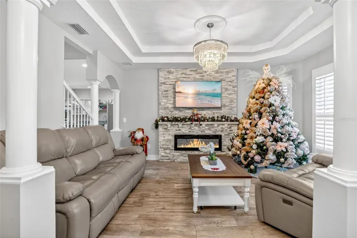 Elegant tray-ceiling living room with cozy fireplace