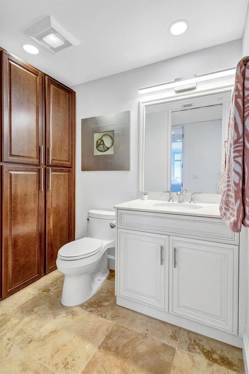Residence Secondary / Guest Bedroom  sink basin with large white cabinetry and stainless steel handles.  Matching mirror and modern lighting