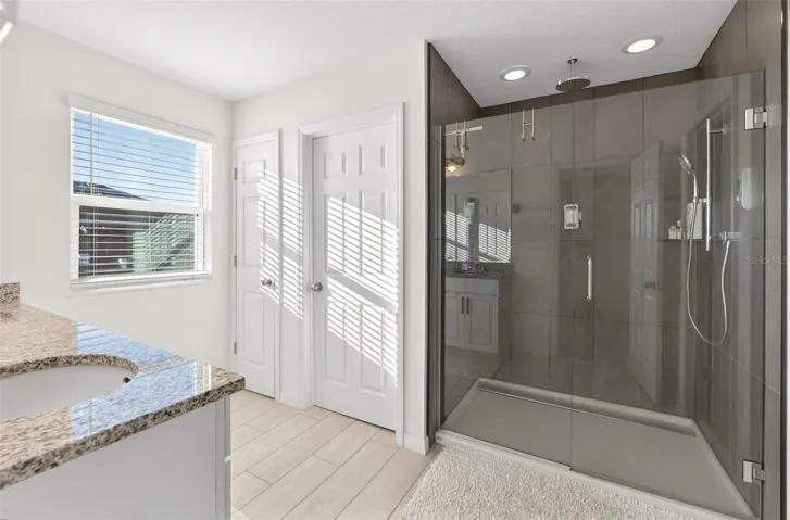 Alternate view of primary bathroom with view of upgraded digital shower