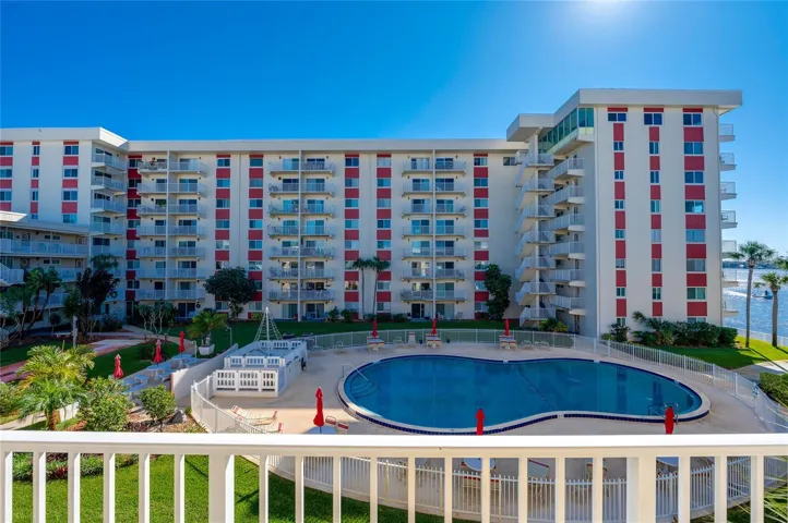 Overlooking the central courtyard, this elevated perspective highlights the well-maintained pool area with ample lounge seating and lush landscaping.