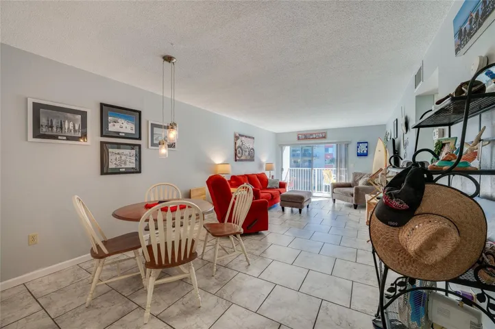 Open-concept living and dining space with tile flooring and a sliding glass door that leads to the balcony for indoor-outdoor living.