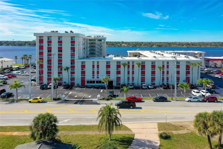 Clean, well-maintained building exterior with bold red accents and ample surface parking, located right off North Halifax Avenue.