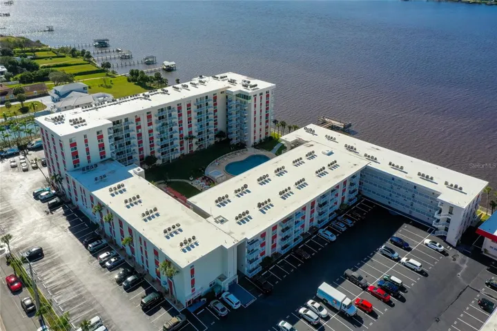 Rear elevation highlights the building’s architectural design, with balconies overlooking the pool area and river.