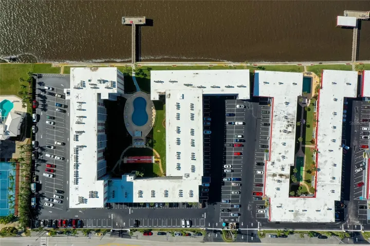 Direct overhead shot outlines the layout of the community, including the oval-shaped pool, dock, green space, and ample parking.
