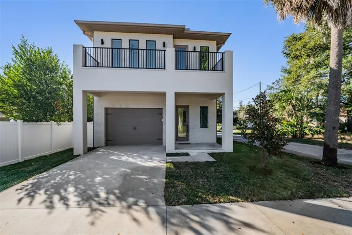 Sleek modern facade with covered entry and balcony