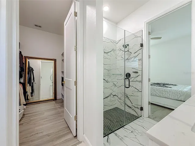 Walk in closet with large shower in primary bath