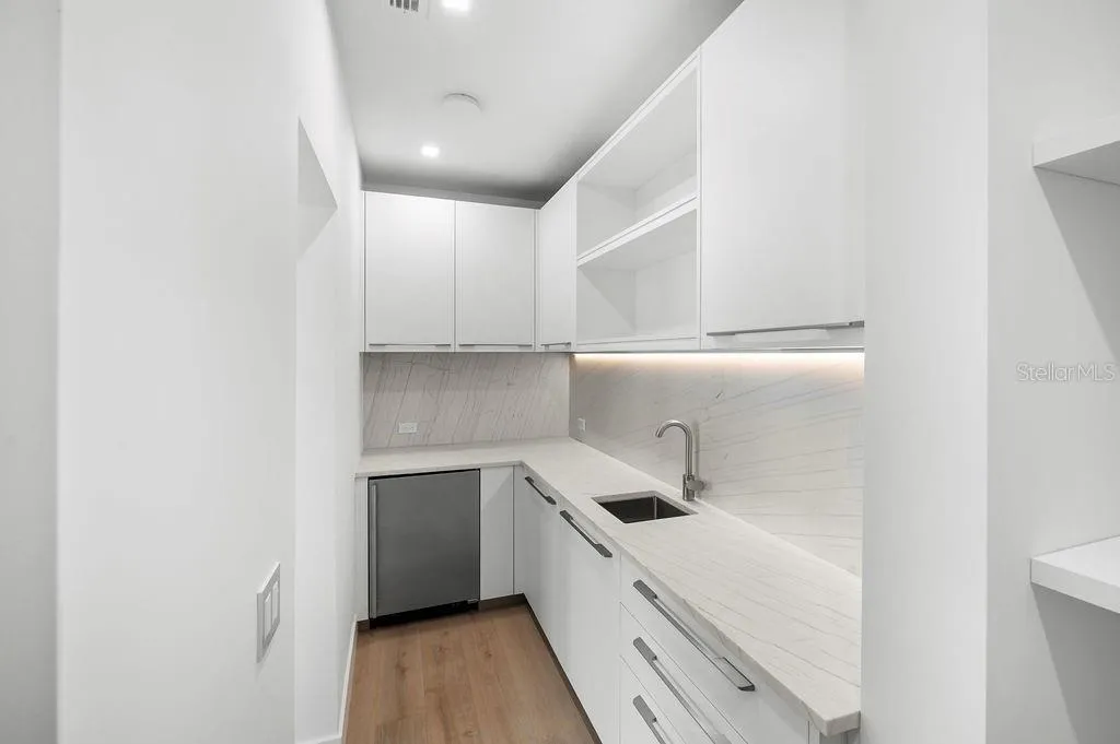 Kitchen hosts a hidden scullery with built in shelving and additional refrigeration