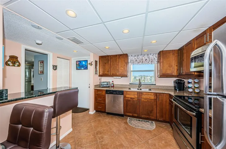 Open and updated kitchen with wood cabinets, granite counter tops, stainless steel appliances