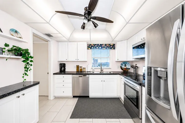 Kitchen with white cabinets, solid surface counter tops, stainless steel appliances