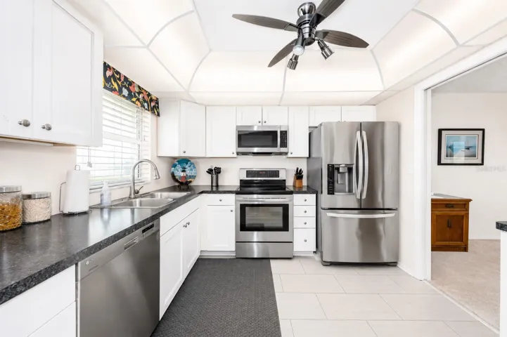 Kitchen with white cabinets, solid surface counter tops, stainless steel appliances